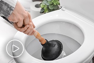 Image of person with plunger trying to unblock toilet