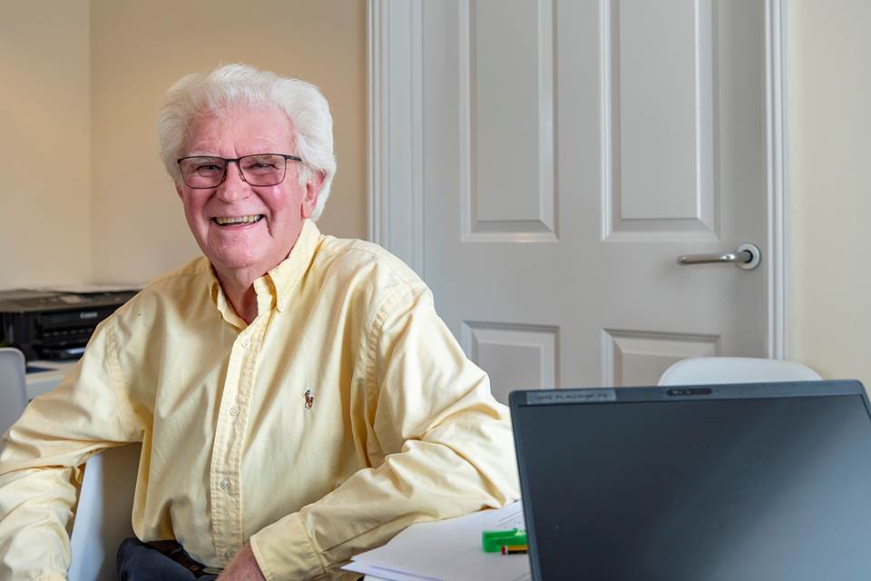 Person sat at desk smiling