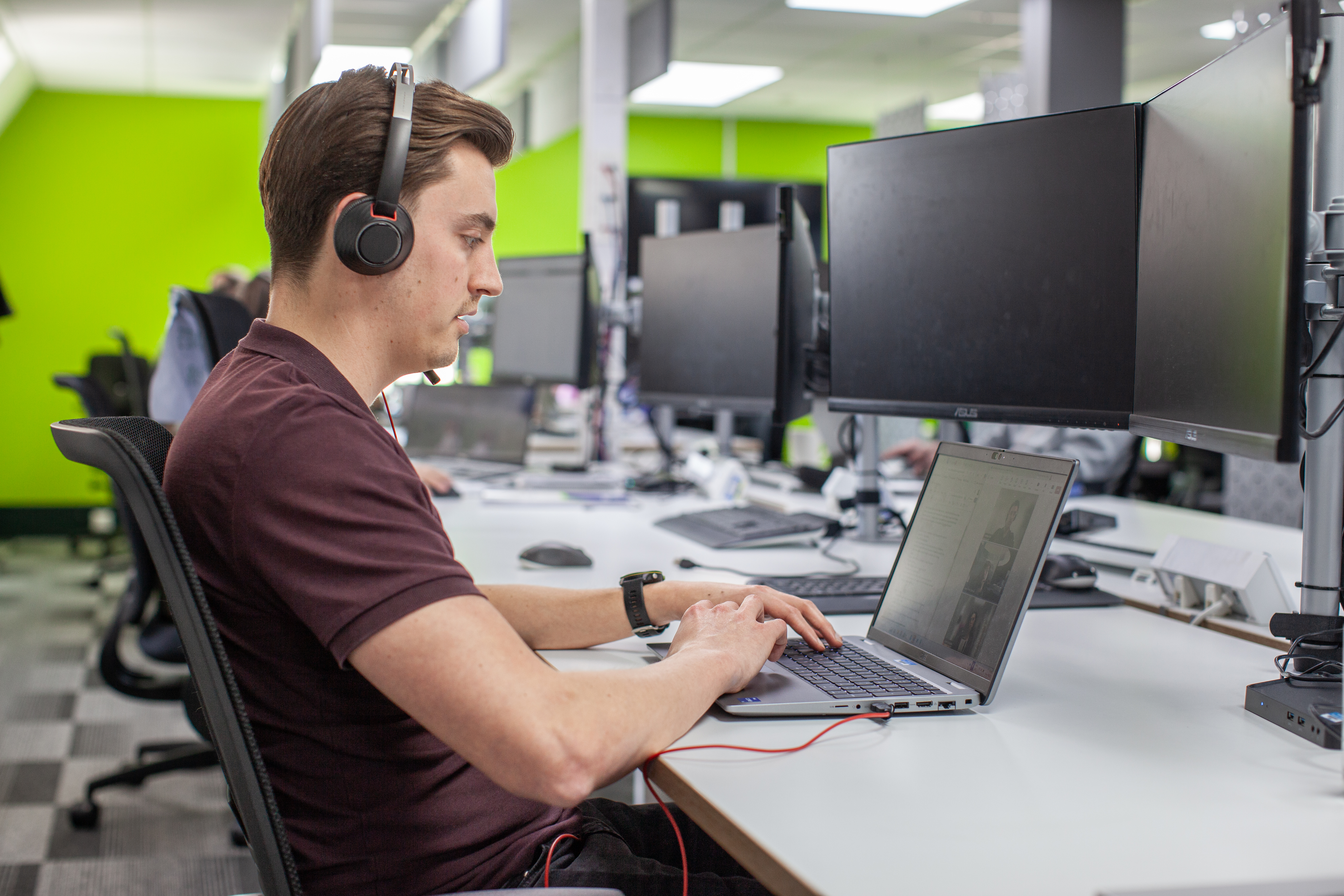 Man on a phone call using a headset at his desk